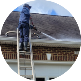 Pressure washing roof and gutters to prevent damage and debris buildup